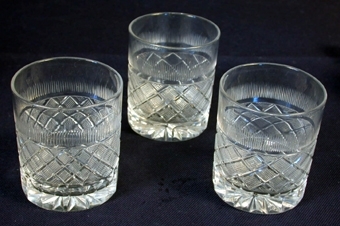 :1-3 Tre stycken likadana cylinderformade dryckesglas av genomskinligt glas. Utsidans yta dekorerad med rutmönster och andra mönster. I bottens undersida ett stjärnmönster.
