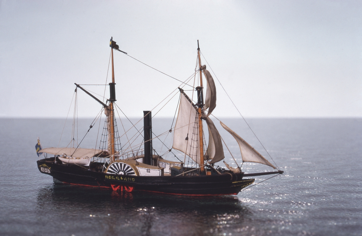 Fartygsmodell på vattenlinje. Hjulångaren "Norrland", hel i block av trä. Fartyget är skonertriggat med segel av bomull. Blå och gul namnvimpel på stortopp och svensk flagga med unionsmärke akterut. I aktern fyra fönster. Fartygsfakta:

60   hkr.

Reg. nr. Sthlm   5    ( SE. 1839)
Föremålets form: Vattenlinjemodell