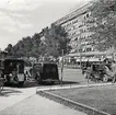 Parkerade bilar, en cyklist och några fotgängare på Vasagatan vid Stockholms central.