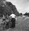 Cyklister, kvinna och man, med packning på pakethållarna står vid Göta kanal.