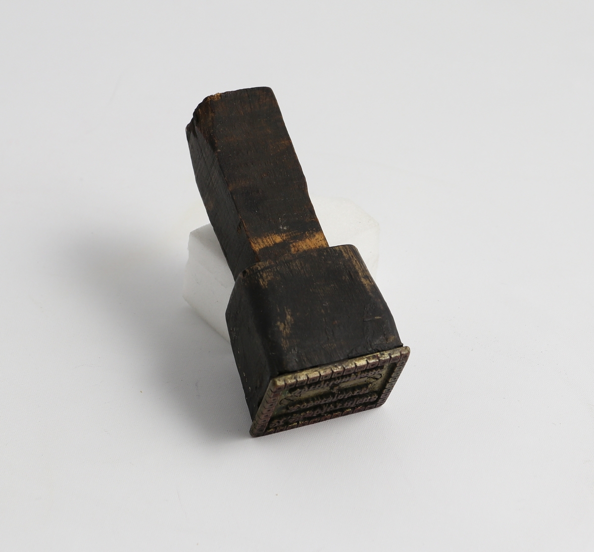 Trehåndtak med trehode og metallstempel. Stemplet sier A. Asbjørnsens Tobaksfabrik Christiansand