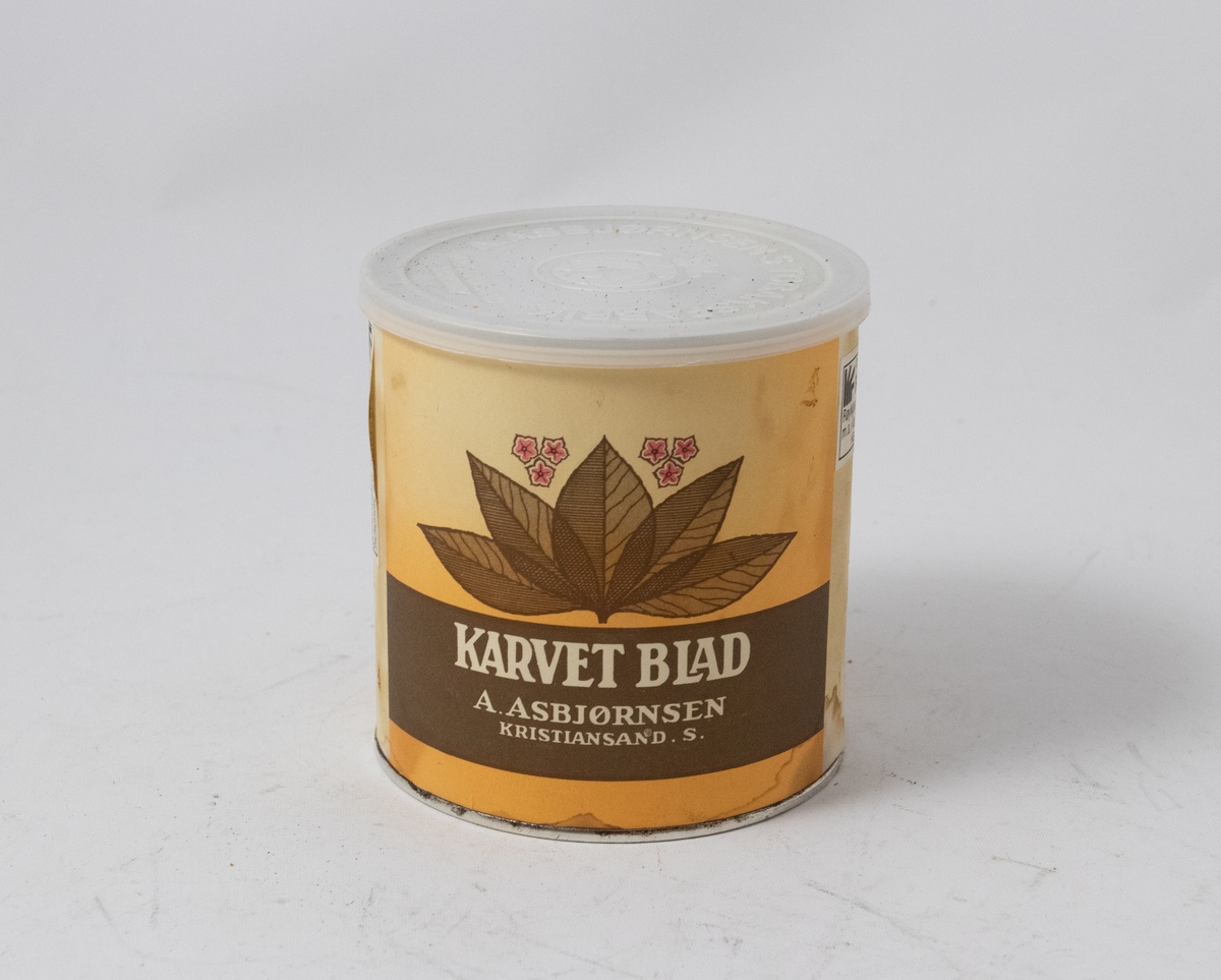 Tobakksblad på gul bakgrunn over hvit logotekst på brun bakgrunn.