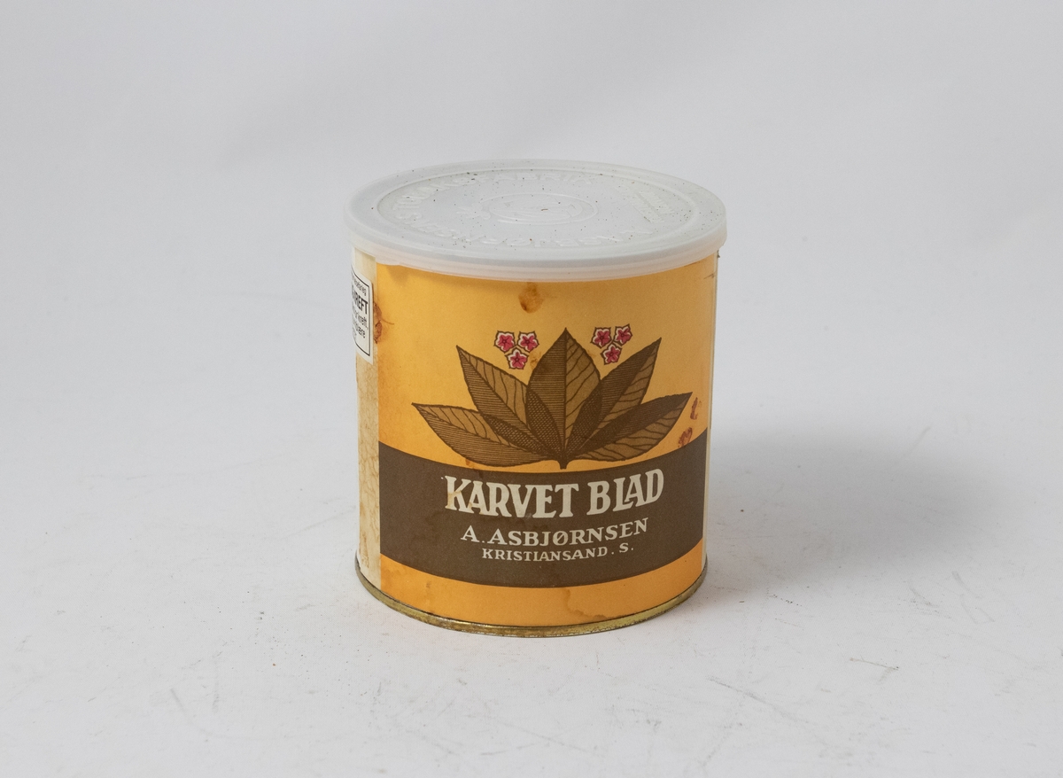 Tobakksblad på gul bakgrunn over hvit logotekst på brun bakgrunn.