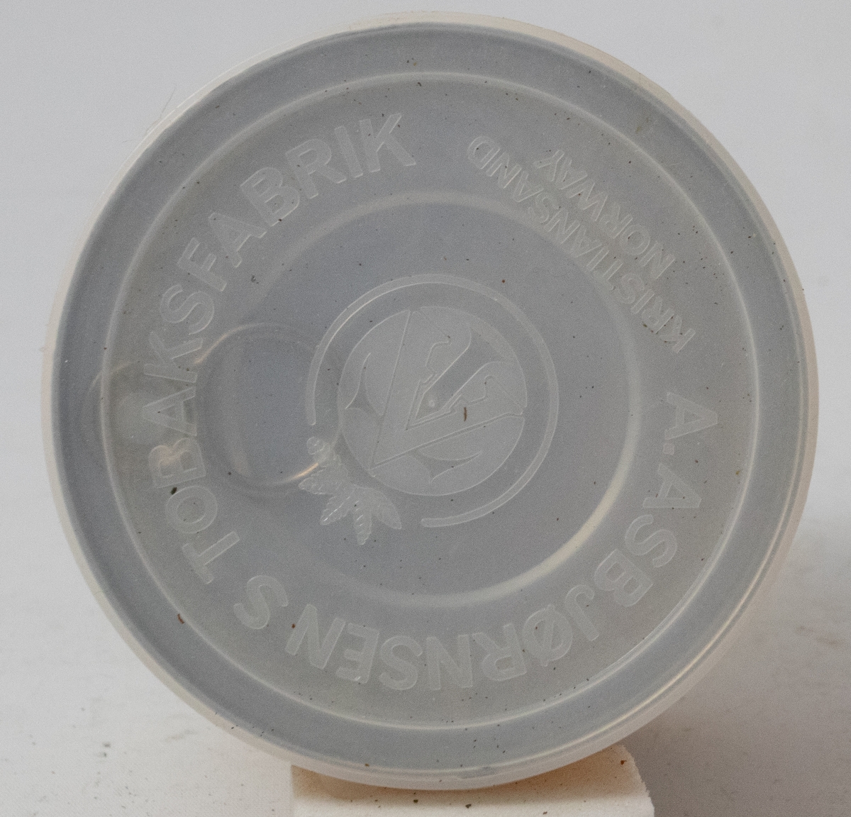 Tobakksblad på gul bakgrunn over hvit logotekst på brun bakgrunn.