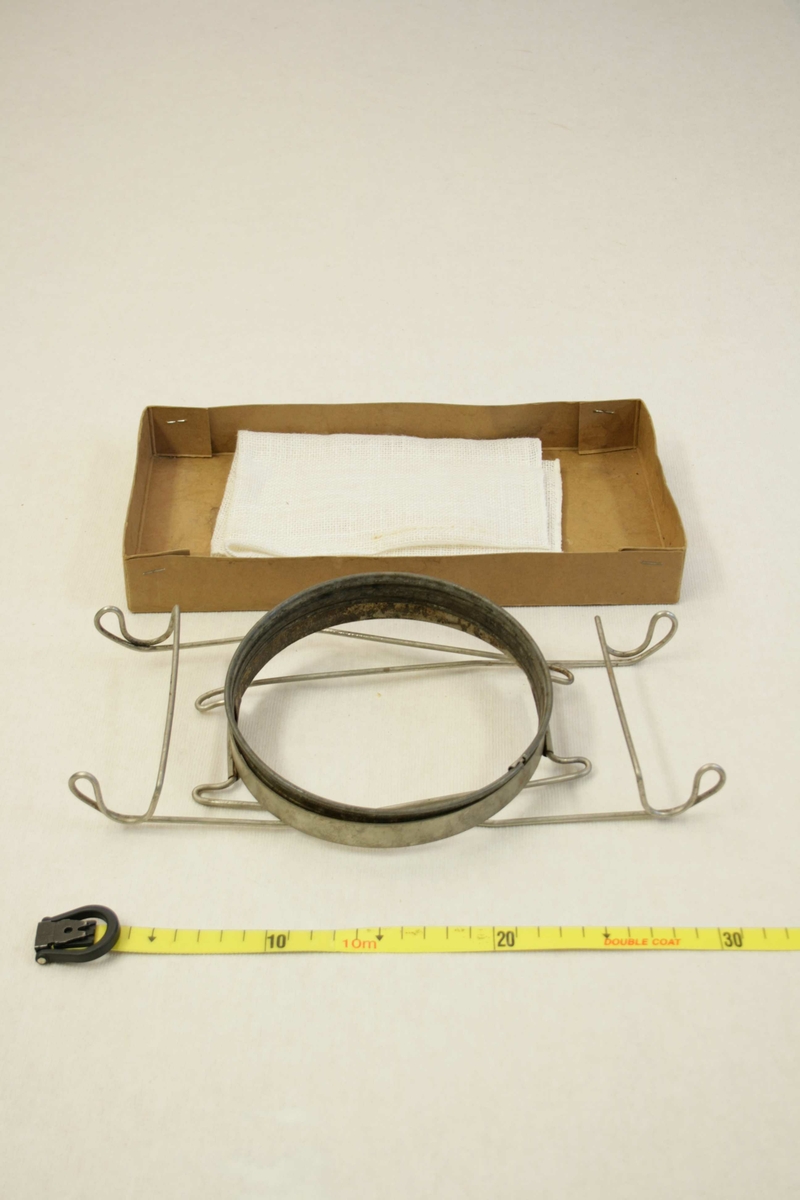 Metallstativ med to metallringer hvor en tekstil-sil festes, i pappeske