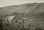 Abisko turiststation, nedan Njullá. Ett vattenfall rinner nedför berget.