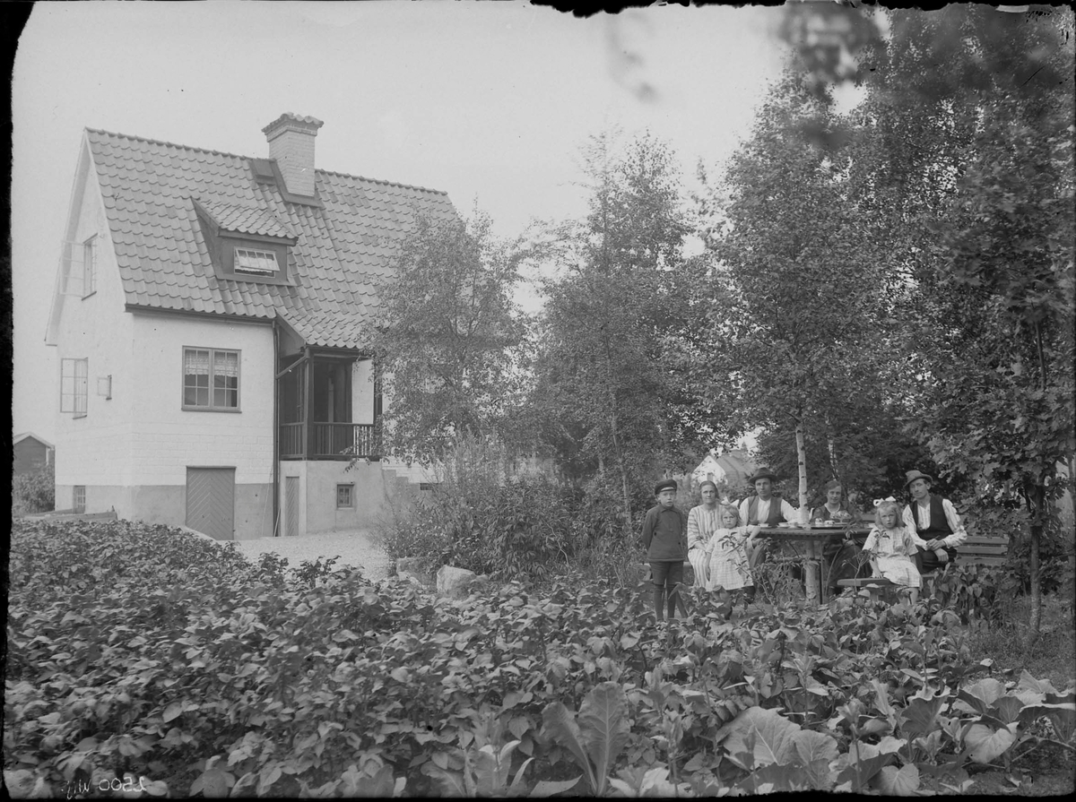 Fotografering beställd av Karlsson. I bild syns sannolikt Axel Emanuel Karlsson (1894-1928) och hans hustru Eva Jakobsson (1896-1988) med sonen Erik Tage Emanuel (1915-1996) längst till vänster. Bosatta på Haga 28. De andra är ej identifierade.