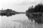 Sommaren 1904 gjorde fotograf Didrik von Essen sig ärende till Hjulsbro med omnejd. Om han lockats av en beställning eller besökte området av eget intresse är oklart men hur som ställde han för detta motiv upp sin kamera uppströms Hjulsbro sluss och frös en unik vy. Mycket i blickfånget är idag förändrat men till vänster om slusspassagen skymtar den gamla stenvalvsbron som ännu utgör ett landmärke. På höjden till vänster ses något av bebyggelsen vid Hjulsbro gård.