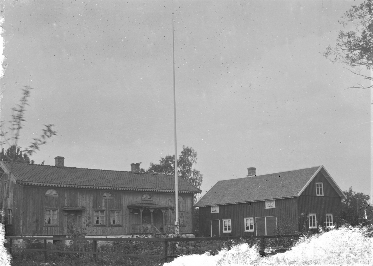 En gammal manbyggnad med en nyare byggnad i vinkel och på gården en mycket hög flaggstång. Det gamla huset är förmodligen en s k långloftsstuga, vilket de två ingångarna antyder. Alltså ursprungligen en gammal högloftsstuga med en lägre ryggåsstuga i mitten och ett högre loft på ömse sida med var sin ingång. Vid godare tider har man fått råd att bygga på och lyfta upp taken till gemensam höjd och sätta in lunettfönster i loftgången som formats på ovanvåningen. Huvudentrén försågs med en veranda dekorerad med figursågade räcken, kapitäl och taklist. I många fall togs den andra ingången bort, men här behölls den och dörren med rombisk panel flankeras av pilastrar och ett kort skärmtak. Längs byggnadens takfot sitter en kraftig, lambrekängformad list. Taket täcks med enkupigt tegel och den höga stensockeln är vitkalkad och har en källaringång. Flygeln är också reslig med loftvåning men har taket täckt med stickor (pärt) och målad fasad, till skillnad från huvudbyggnaden. (Bilden beskuren pga negativets skador, ses nedtill och till vänster)