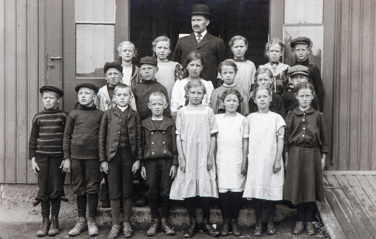 Klassebilde fra Kløfta skole, gruppe 19 elever og lærer Eivind Hovind, født i Løten (1885-1948), han var lærer i Stange kommune, gift med Berthe Honerud. Her muligens fra Kløfta skole, der han var skolestyrer. Han var også kirkesanger. 
Ukjente elever.
