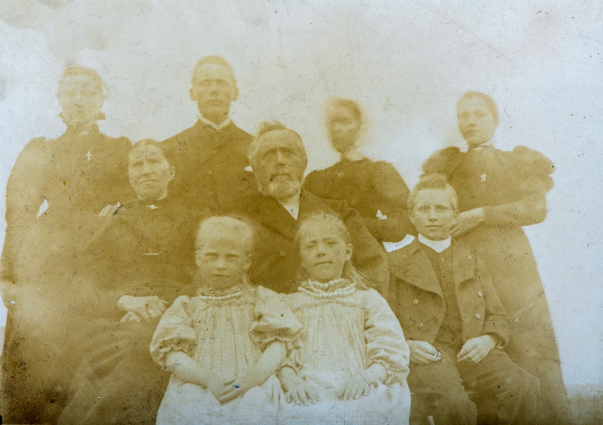 Familiegrupp 9 personer. Mikkel Hovind 1835-1915, Hovind i Løten kommune, omgitt av noen av barna sine. 
Fra venstre bak, Anne Julie Hovind? Født 1873, Emil Hovind, født 1871, ukjent, ukjent
Venstre 2. rekke Pettrine Hovind, født Sæther  1848-1920, gift med Mikkel Hovind, Eivind Hovind 1885-1948, lærer i Stange kommune, ved Kløfta og Kjeverud skole
Første rekke: Inga Pauline Hovind, født 1890, lærer i Romedal, gift med emissær Karl Govertsen fra Lillesand, Kristofine Hovind, født 1887, hustellærer i Åmot.