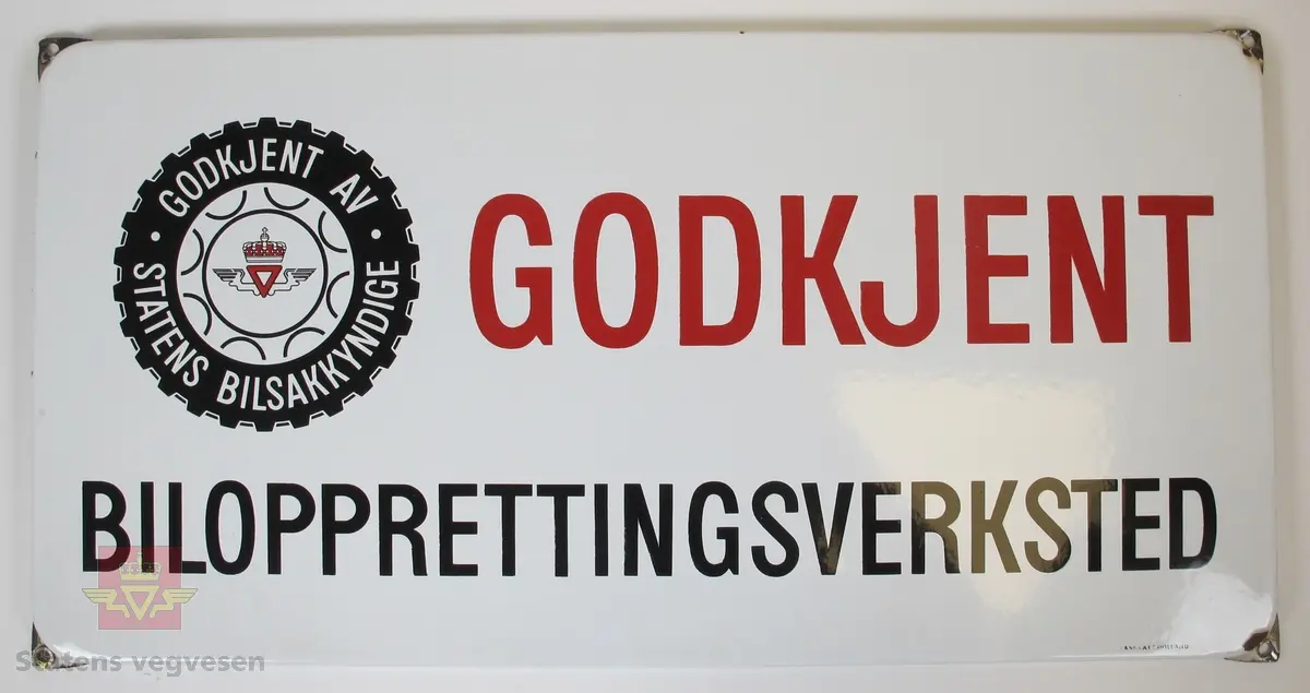 Hovedsakelig hvitt, rødt og svart emaljeskilt laget av metall. Det er et skruehull i hvert hjørne og anntydning til flaking av lakk/rust på alle hullene. Skiltet er i god stand ellers.