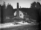 Trots att tidens gång påverkat bildens kvalitet får vi skatta oss lyckliga över denna unika dokumentation av Råby chokladfabrik. Industrin på Råbys ägor invid Motala ström hade redan vid tiden för bilden gamla anor som bland annat yllestamp, färgeri och oljeslageri, men epoken som chokladfabrik var kort, knappa tio år. Rörelsen grundades 1892 av den i Motala verksamma grosshandlaren John Anderson, varför rörelsens egentliga namn var Motala chokladfabrik. Efterhand övertogs verksamheten av Cloetta med Olof German Svensson som disponent och under dennes ledning växte tillverkningen fort förbi platsens kapacitet. Ny fabrik, dagens Cloetta, kom därför att uppföras vid Malfors. När den stod klar 1902 var den upplysningsvis Skandinaviens största chokladfabrik.