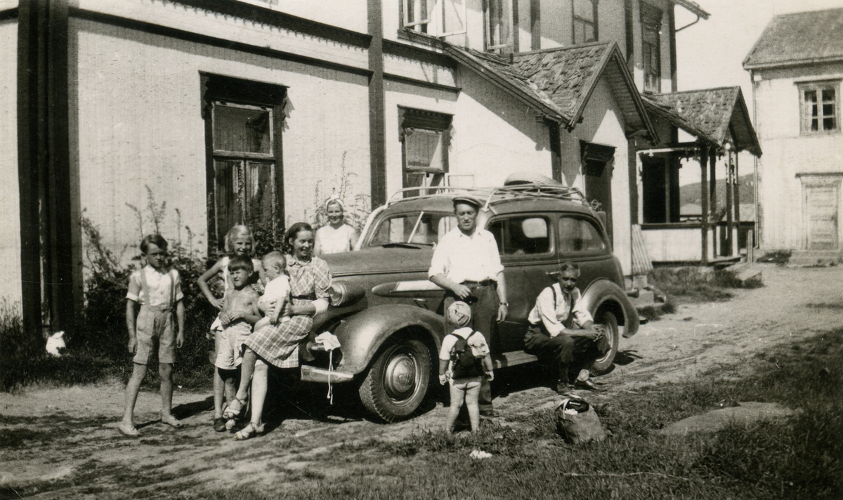 Barn og voksne foran bil
