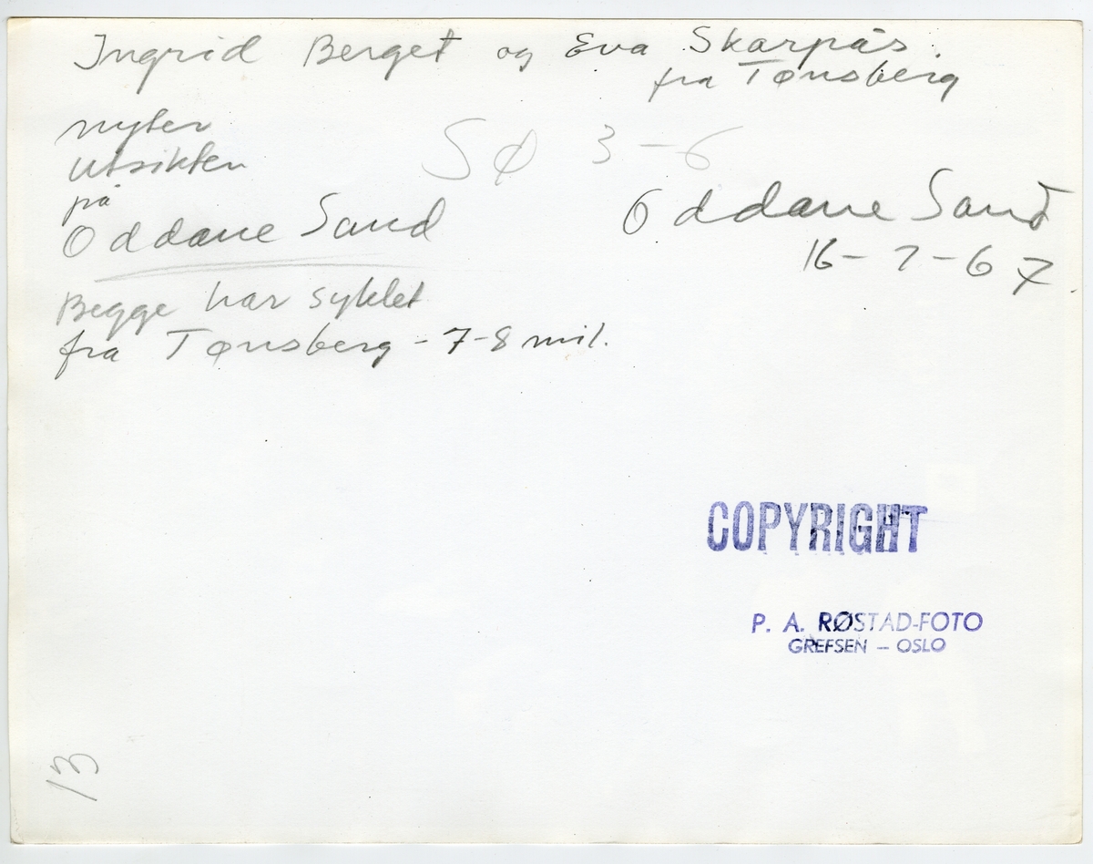 Baksiden til fotografi av to kvinner sitter på et berg ovenfor en campingplass.