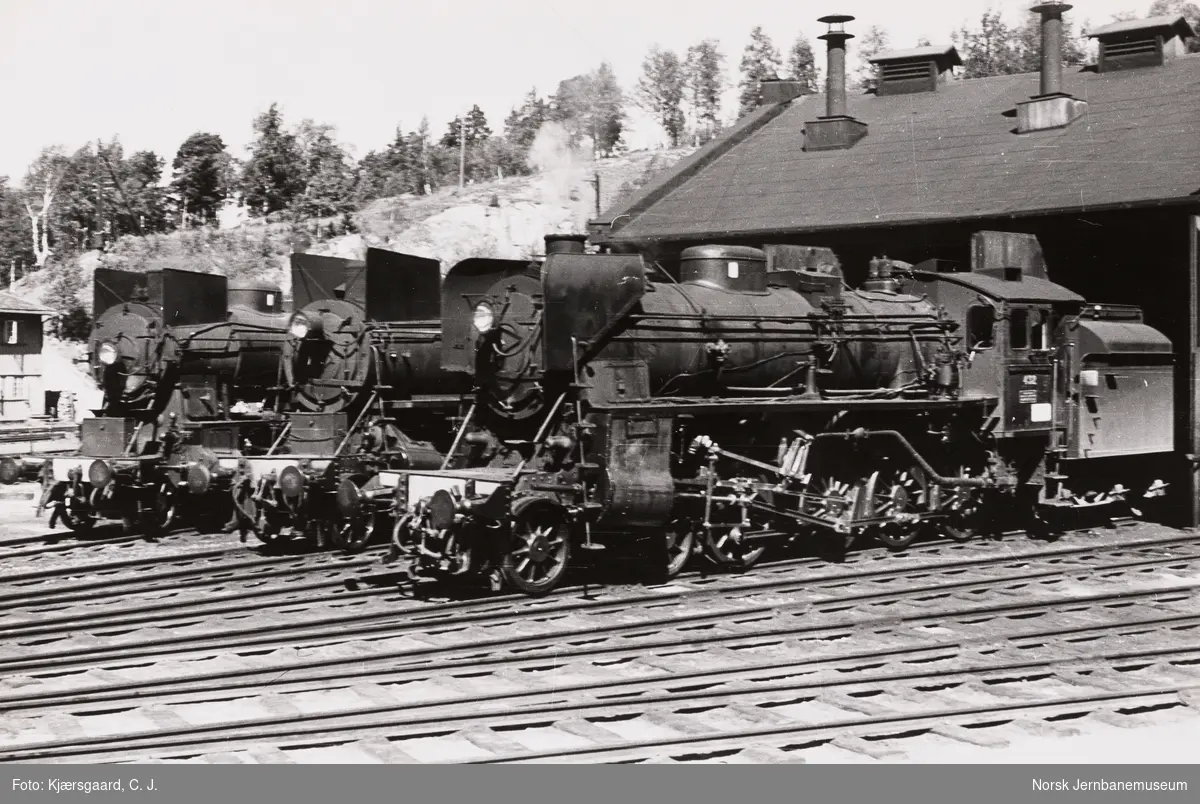 Damplokomotiver foran lokomotivstallen på Dombås stasjon. Fra høyre type 26c nr. 432, type 26a og type 30b