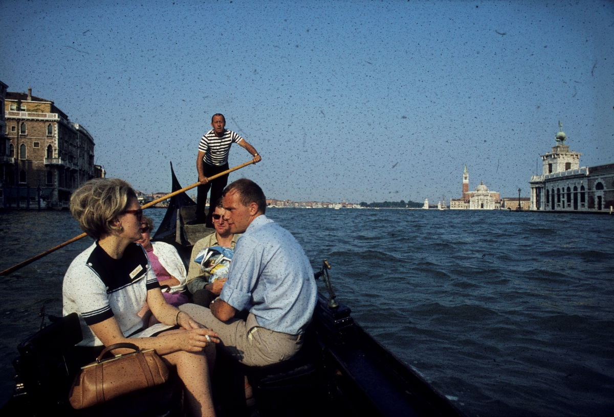 Foto av passasjerer i en gondol, på kanalen i Venezia.