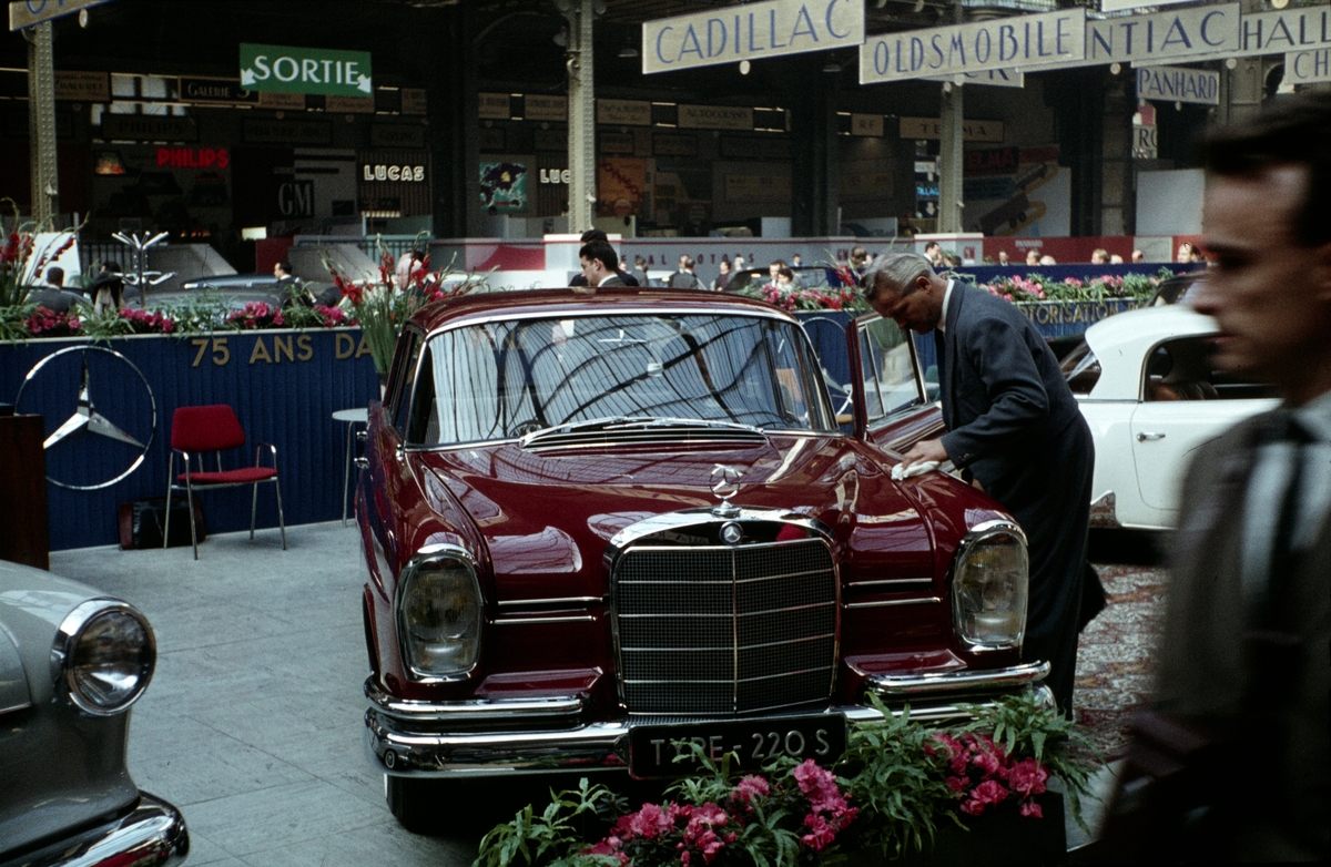 Foto fra en bilmesse i Frankrike. Menn studerer en Mercedes.