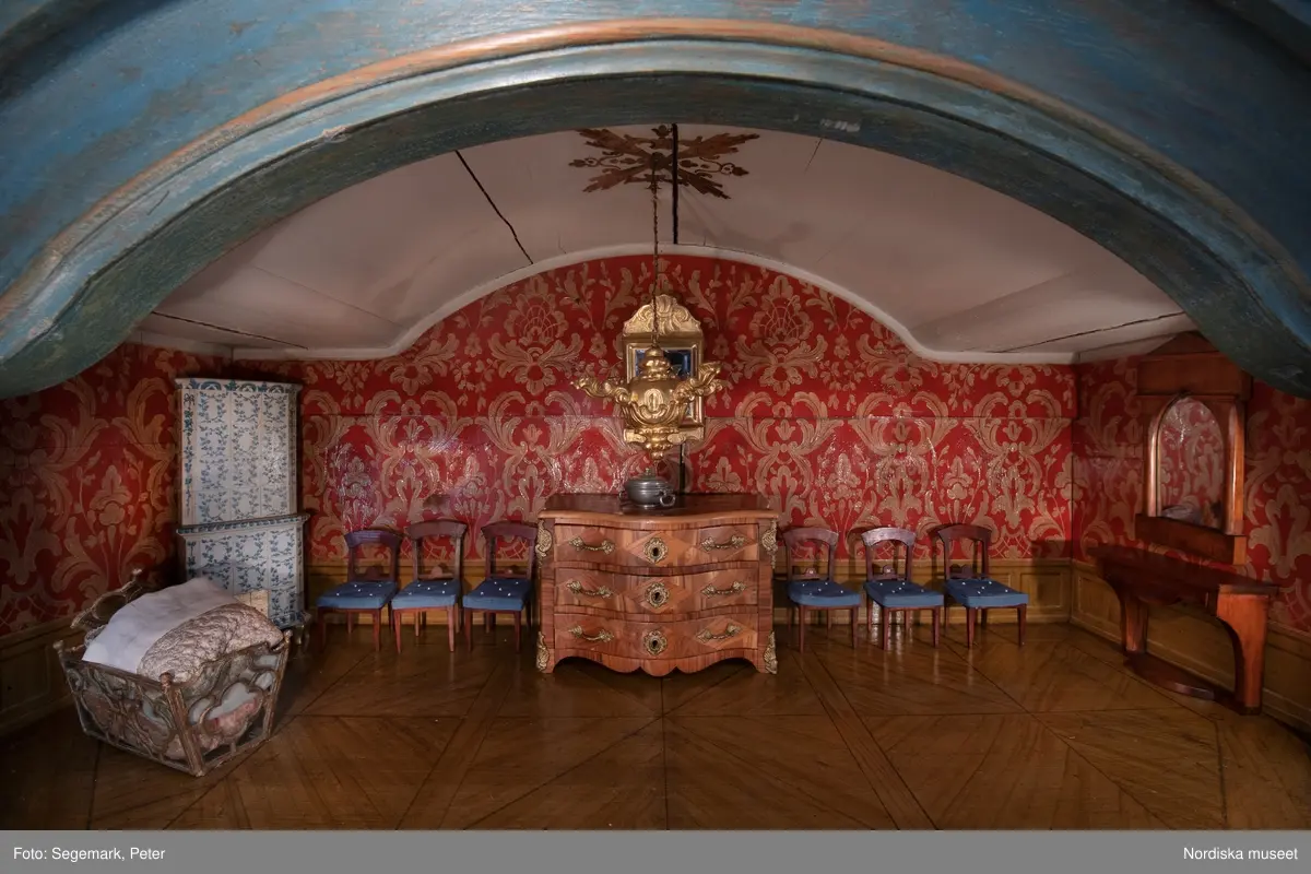 Dockskåp i utställningen "Dockskåp", visad på Nordiska museet 23 dec 1999 - 20 jan 2021.
Det blå kabinettskåpet, år 1760. Skåpet gjordes i ordning för Maria Catharina Falk som var en liten flicka vid mitten av 1700-talet. Det har ärvts och ändrats av andra. På väggarna hänger äkta porträtt av hennes och makens släkt.
I köket står en servis av fajans tillverkad 1746 vid Rörstrands porslinsfabrik. 
NM.0151825