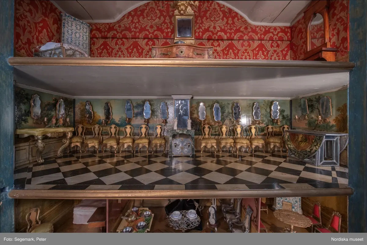 Dockskåp i utställningen "Dockskåp", visad på Nordiska museet 23 dec 1999 - 20 jan 2021.
Det blå kabinettskåpet, år 1760. Skåpet gjordes i ordning för Maria Catharina Falk som var en liten flicka vid mitten av 1700-talet. Det har ärvts och ändrats av andra. På väggarna hänger äkta porträtt av hennes och makens släkt.
I köket står en servis av fajans tillverkad 1746 vid Rörstrands porslinsfabrik. 
NM.0151825