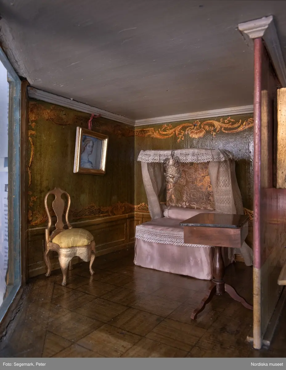 Dockskåp i utställningen "Dockskåp", visad på Nordiska museet 23 dec 1999 - 20 jan 2021.
Det blå kabinettskåpet, år 1760. Skåpet gjordes i ordning för Maria Catharina Falk som var en liten flicka vid mitten av 1700-talet. Det har ärvts och ändrats av andra. På väggarna hänger äkta porträtt av hennes och makens släkt.
I köket står en servis av fajans tillverkad 1746 vid Rörstrands porslinsfabrik. 
NM.0151825
