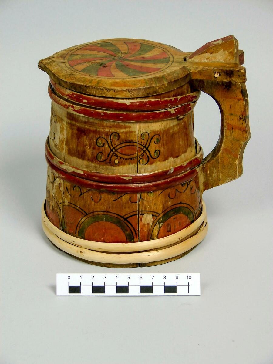 Dryckeskannor. A (brun): Dryckeskanna, av trä, laggad, med tre dubbelband. Konisk. Med lock. Gulfernissad. Locket med virvelstjärna i rött och grönt. Kring kannan nederst halvcirkelformiga, därovanför slingformiga och överst beslagsliknande ornament i rött, grönt och svart. Bottens undersida märkt m brännstämpel: M MS, inristat: IHD. Banden i rödbrunt. Diam(nedtill) 14,5 cm. H. 18,8 cm. Doroeta socken, Lappland. 
B Drickeskanna, av granträ, laggad. Ett band övriga bortfallna. Snidat trähandtag i svängda former. Propp överst i buktiga locket, bortfallen. Mörkgrön färg med blomdekor i rött, svart, vitt. Målningen delvis hårt sliten. Undertill ristat klumpigt BLD. Höjd 16 cm., diam. 13 cm. Inköpt av fru Johansson, Härnösand, april 1917, från Dorotea socken, Lappland. 
C (blå): Dryckeskanna av trä. Laggad, cylindrisk. Försedd med 4band placerade 2 och 2. Lodgrepe, överst med tumgrepp samt gångjärn till locket. Grepen har eventuellt haft 2 grepp varav det yttre(?) är avbrutet. Locket är cylindriskt med konvex ut- och konkav insida. Framtill är en liten spets utdragen. Bottnen är fäst i fasat spår i stavarnas nederdel. Blåmålad med stiliserade blommor i beige, gult och rött på svarta kvistar. Banden och lockets kant är röda. Brännstämpel på undersidan: Ett konstigt E med prickar över. 