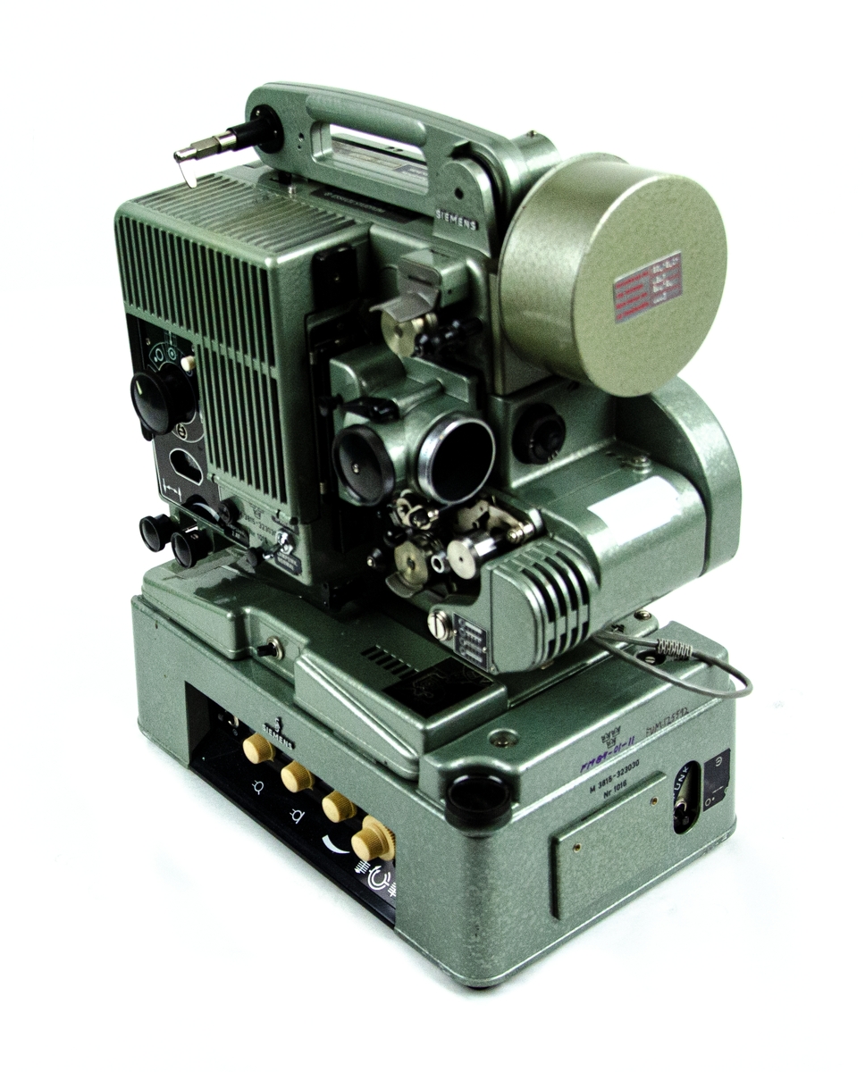 Filmprojektor Siemens 2000 16MM. Avancerad projektor med en mängd inställningsmöjligheter. Inbyggd förstärkare med uteffekt 10W. Bland inställningsmöjligheterna finns bland annat filmhastighet, uppspelningsriktning volym- och tonkontroll. Förvarad i en grön trälåda. Bärbar, med handtag.