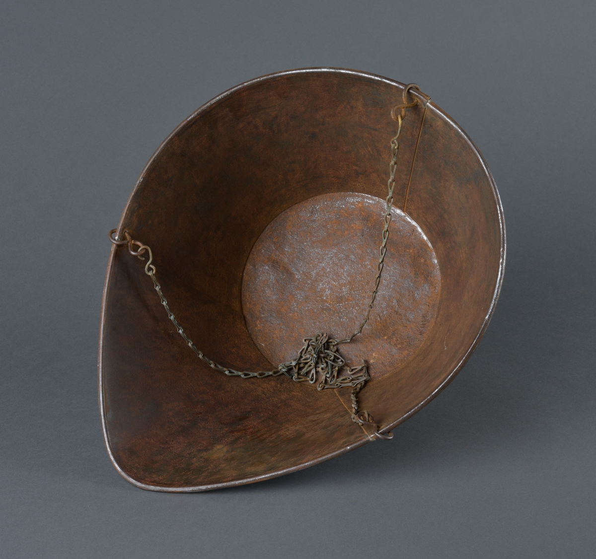 Skålvekt i metall. 
Mangler loddene for vekta, som skal stå på brettet. 
Skåla, hvor det som skulle veies ble plassert er dråpeformet. Antatt fordi det som skulle veies enklere kunne helles ut. 
Noe rust.
Består av to deler. Skålvekt og oppheng