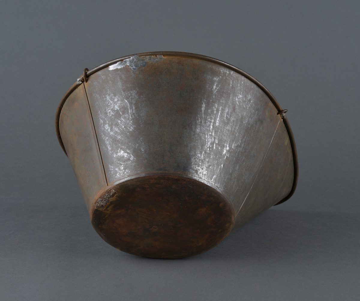 Skålvekt i metall. 
Mangler loddene for vekta, som skal stå på brettet. 
Skåla, hvor det som skulle veies ble plassert er dråpeformet. Antatt fordi det som skulle veies enklere kunne helles ut. 
Noe rust.
Består av to deler. Skålvekt og oppheng