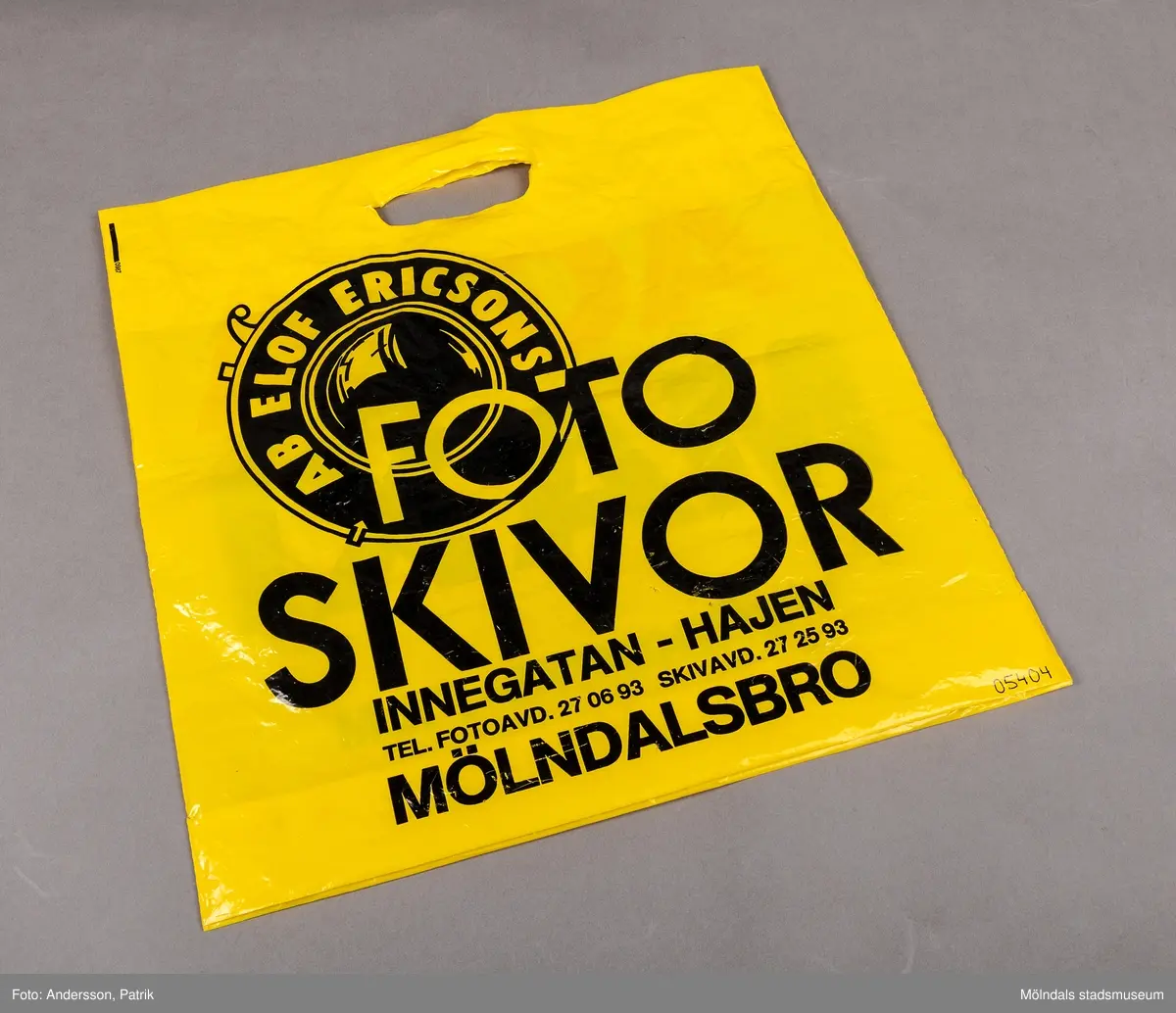 En gul kvadratisk plastpåse med svart eller röd text på både fram och baksidan. Bokstäverna består av endast versaler. Påsen har reklamtext från en foto och skivaffär. Påsens form är avsedd för att en LP skiva ska rymmas,
Butiken som hade påsarna heter AB Elof Ericsons Foto Skivor och är fortfarande belägen i Mölndal. Idag är butiken främst orienterad mot foto.
Då påsen tillverkades hade butiken en fotoavdelning och en skivavdelning.