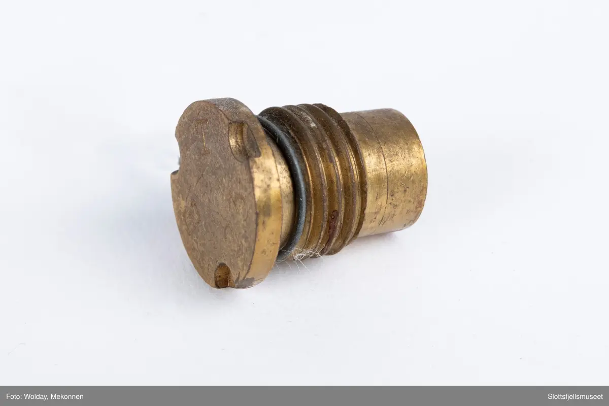 Treeske med skyvelokk, papirmerke med følgende påskrift (trykk): ELLEFSENS TENDSKRUEFABRIKK, STOKKE ST., NORWAY. 50 TENNSKRUER FOR BAKLADE-HVALKANON (DETONATORS FOR BREECH-LOADER WHALING GUN), samt bildet av en tennskrue.
Esken inneholder dessuten én stk tennskrue.