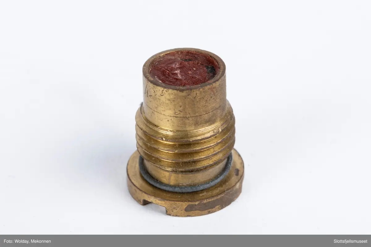 Treeske med skyvelokk, papirmerke med følgende påskrift (trykk): ELLEFSENS TENDSKRUEFABRIKK, STOKKE ST., NORWAY. 50 TENNSKRUER FOR BAKLADE-HVALKANON (DETONATORS FOR BREECH-LOADER WHALING GUN), samt bildet av en tennskrue.
Esken inneholder dessuten én stk tennskrue.