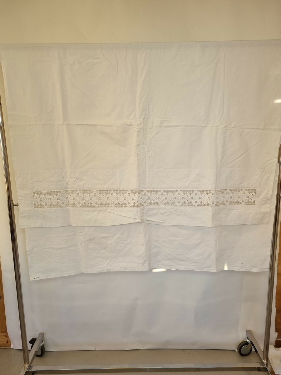 Bomull, lerret, hvit.
Mellomverk med håndbrodert hardanger og hullsøm "stoppesøm" som bord.
Monogram "A S" i tykksøm med blomsterranker.

Se HH.1982-0183 forkle, kvinne