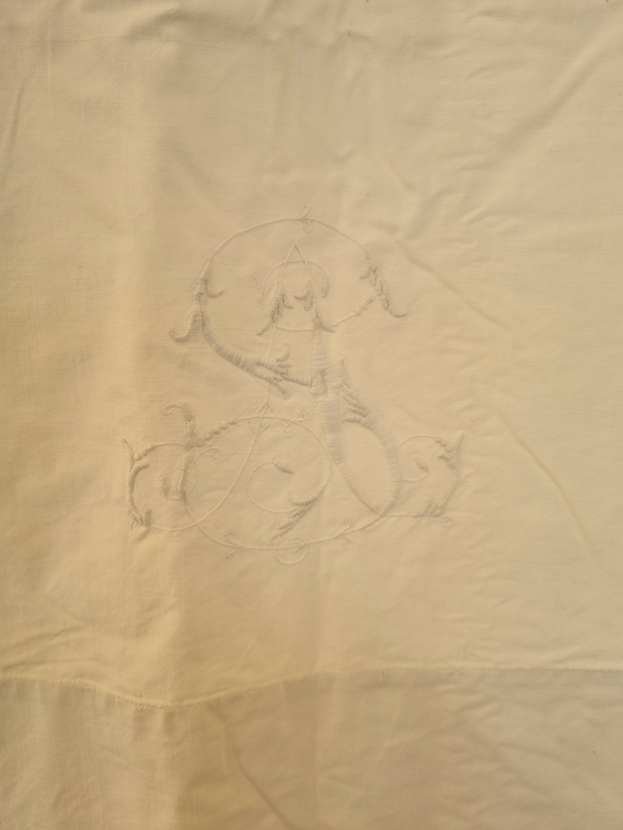 Bomull, lerret, hvit.
Mellomverk med håndbrodert hardanger og hullsøm "stoppesøm" som bord.
Monogram "A S" i tykksøm med blomsterranker.

Se HH.1982-0183 forkle, kvinne