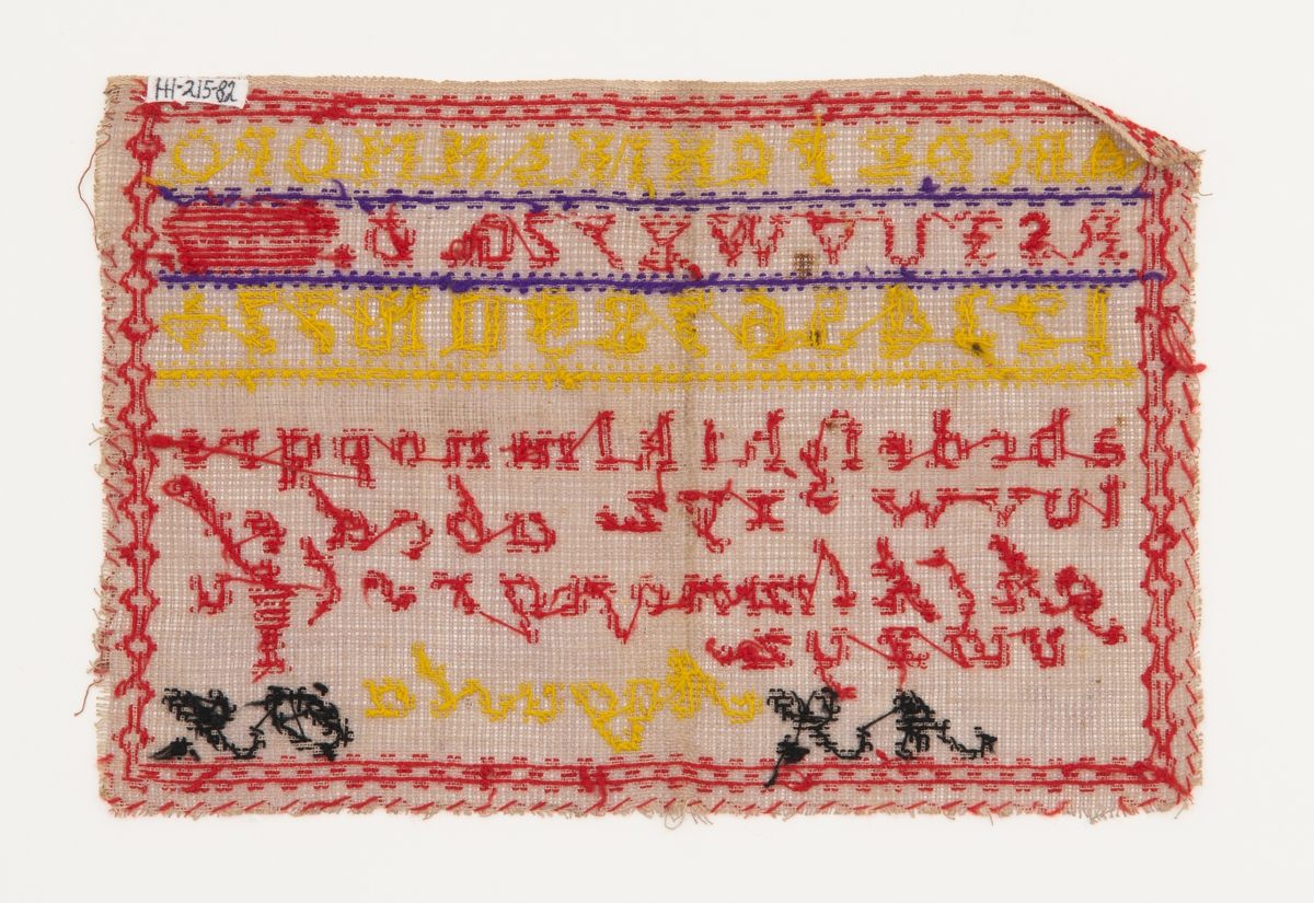 Beige strammei.
Brodert ulltråd, korssting.
Trå rød, gul, sort og lilla.
Brodert: to alfabeter, tall, krone, timeglass. 
"AS" "OS" "Augusta" "1877"