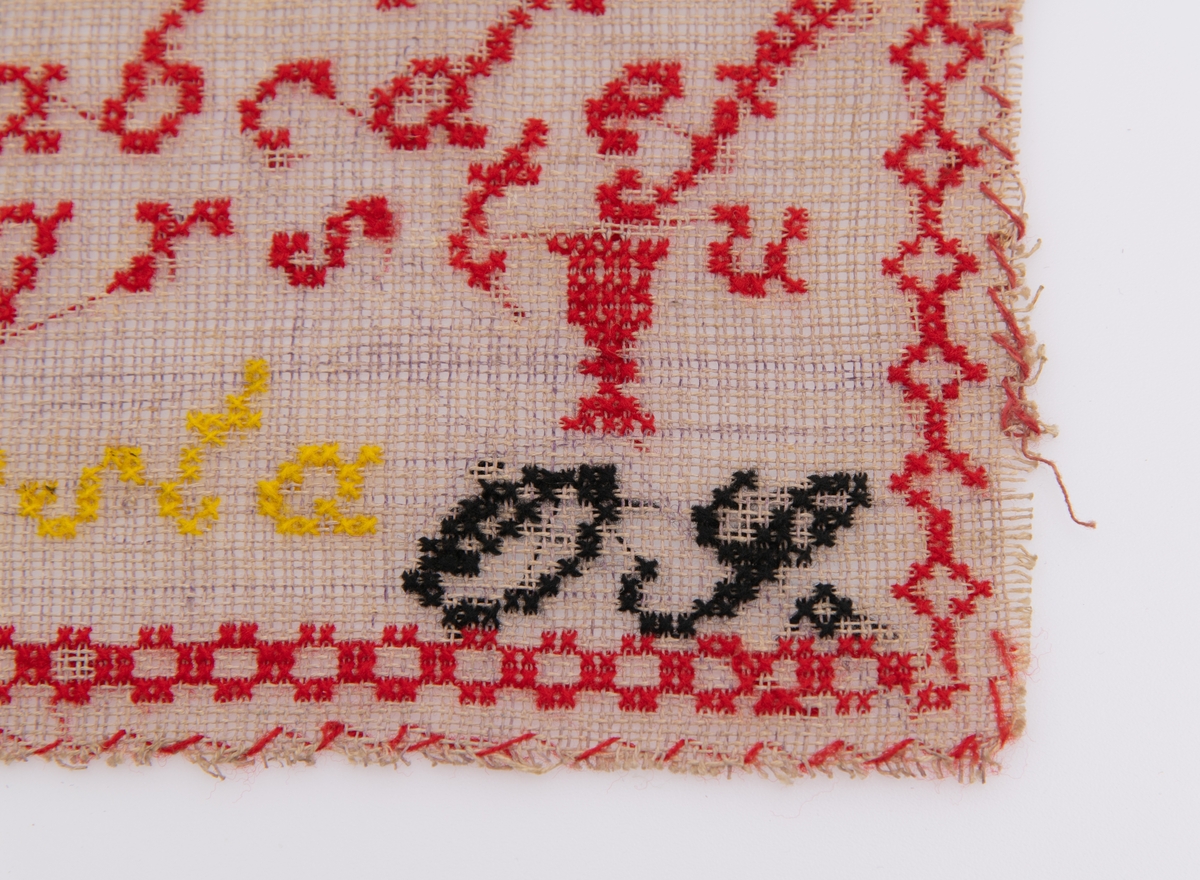 Beige strammei.
Brodert ulltråd, korssting.
Trå rød, gul, sort og lilla.
Brodert: to alfabeter, tall, krone, timeglass. 
"AS" "OS" "Augusta" "1877"