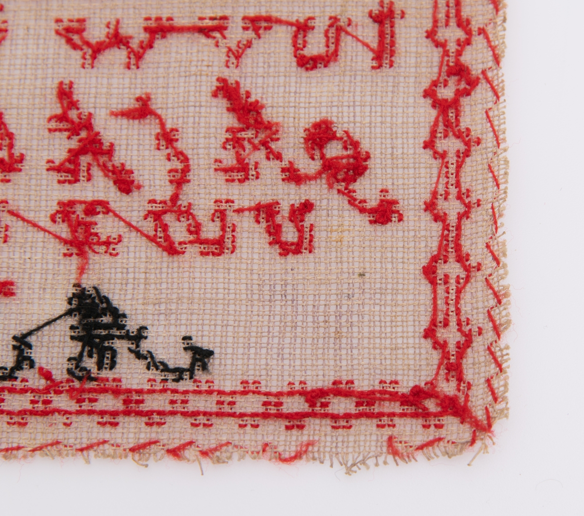 Beige strammei.
Brodert ulltråd, korssting.
Trå rød, gul, sort og lilla.
Brodert: to alfabeter, tall, krone, timeglass. 
"AS" "OS" "Augusta" "1877"