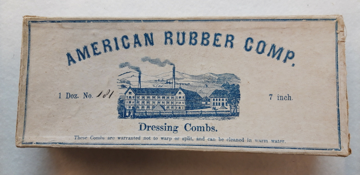 Eske med løst lokk som opprinnelig har inneholdt "dressing combs" fra American rubber comp. Esken kom til museet med mange blonder.