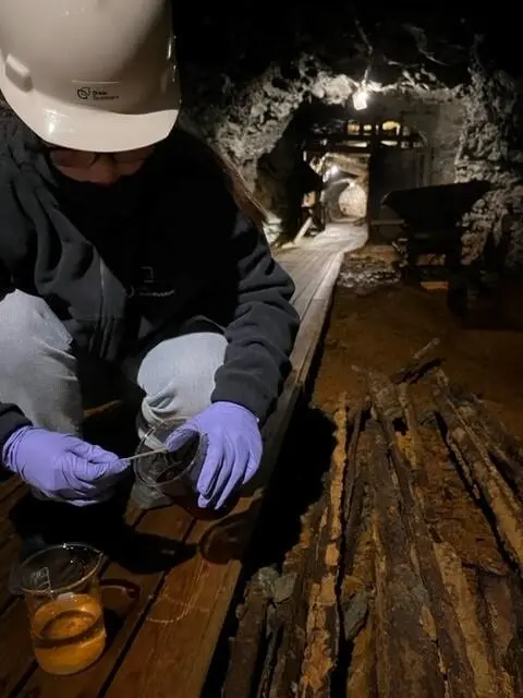 Jente tar vannprøver inne i Gammelgruva. 