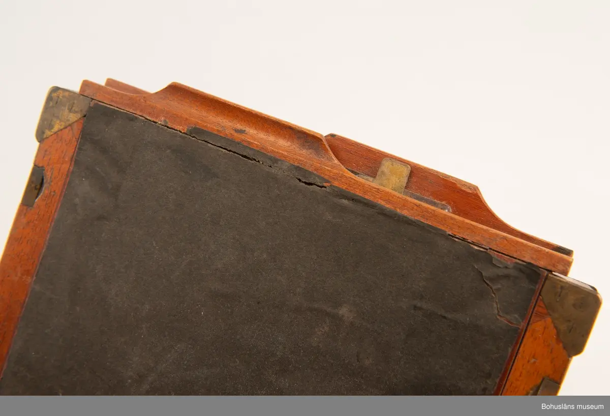 Kassett av mahogny med detaljer av mässing för glasplåtar. Tillhör UM034202 Kamera.