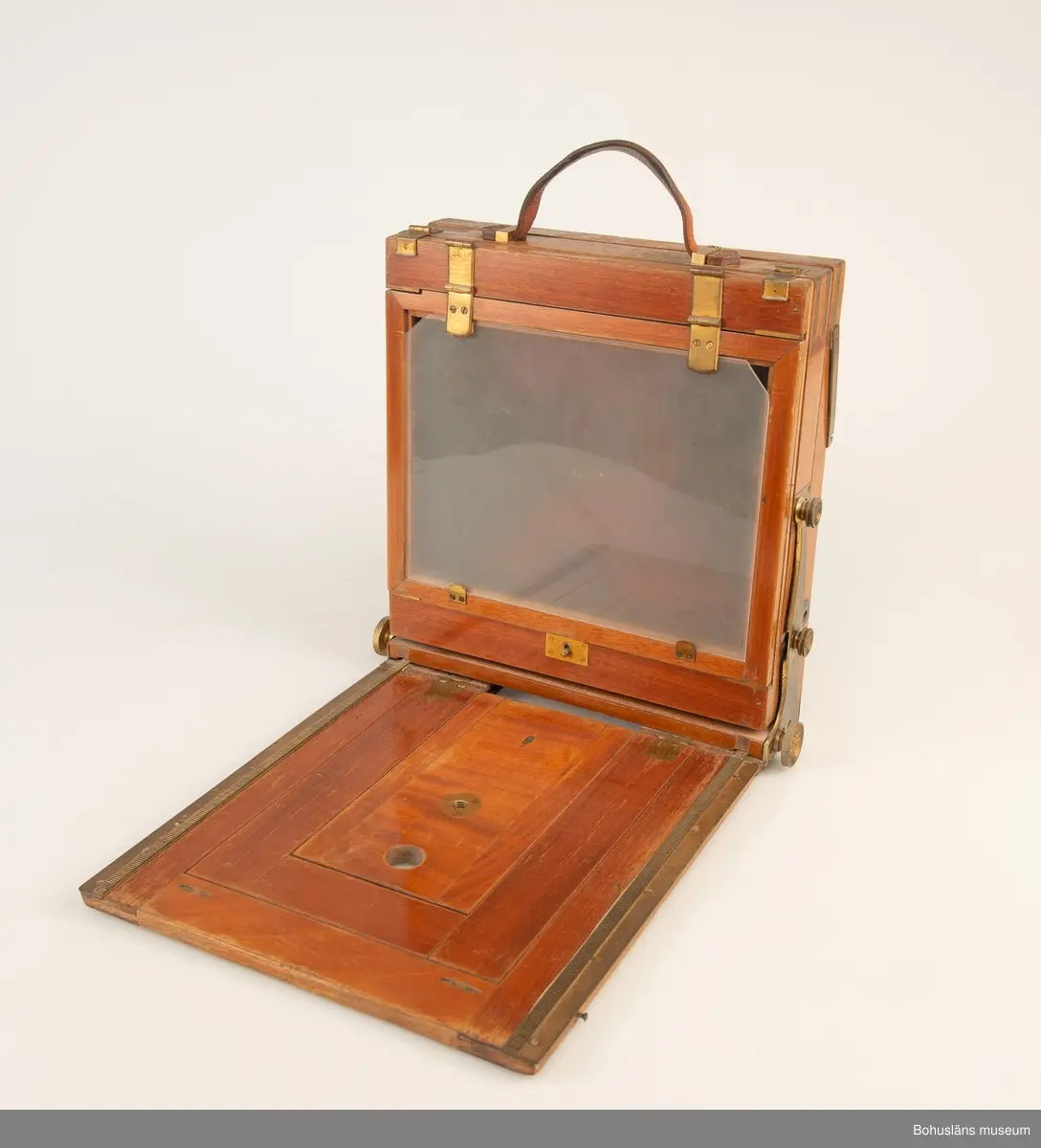 Kamerahuset tillverkat i mahogny med bälg i svart textil och läderhandtag med företagets namn inpräglat.
Kameran har ett dubelanastigmatiskt objektiv monterat,  tillverkat av C. P Goerz i Berlin med en brännvidd på 240 mm och en bländare som kunde ställas in mellan 1:4,8 och 1:384. Slutaren som monterades på objektivet saknas idag. Objektivet märkt: P G GOERTZ BERLIN DOPFEL ANASTIGMATER. Ett sammetsklätt objektivskydd i papp.
Till kameran hör UM034203 Stativ i fodral, UM034204 Objektiv och UM034205-UM034206 Ram.