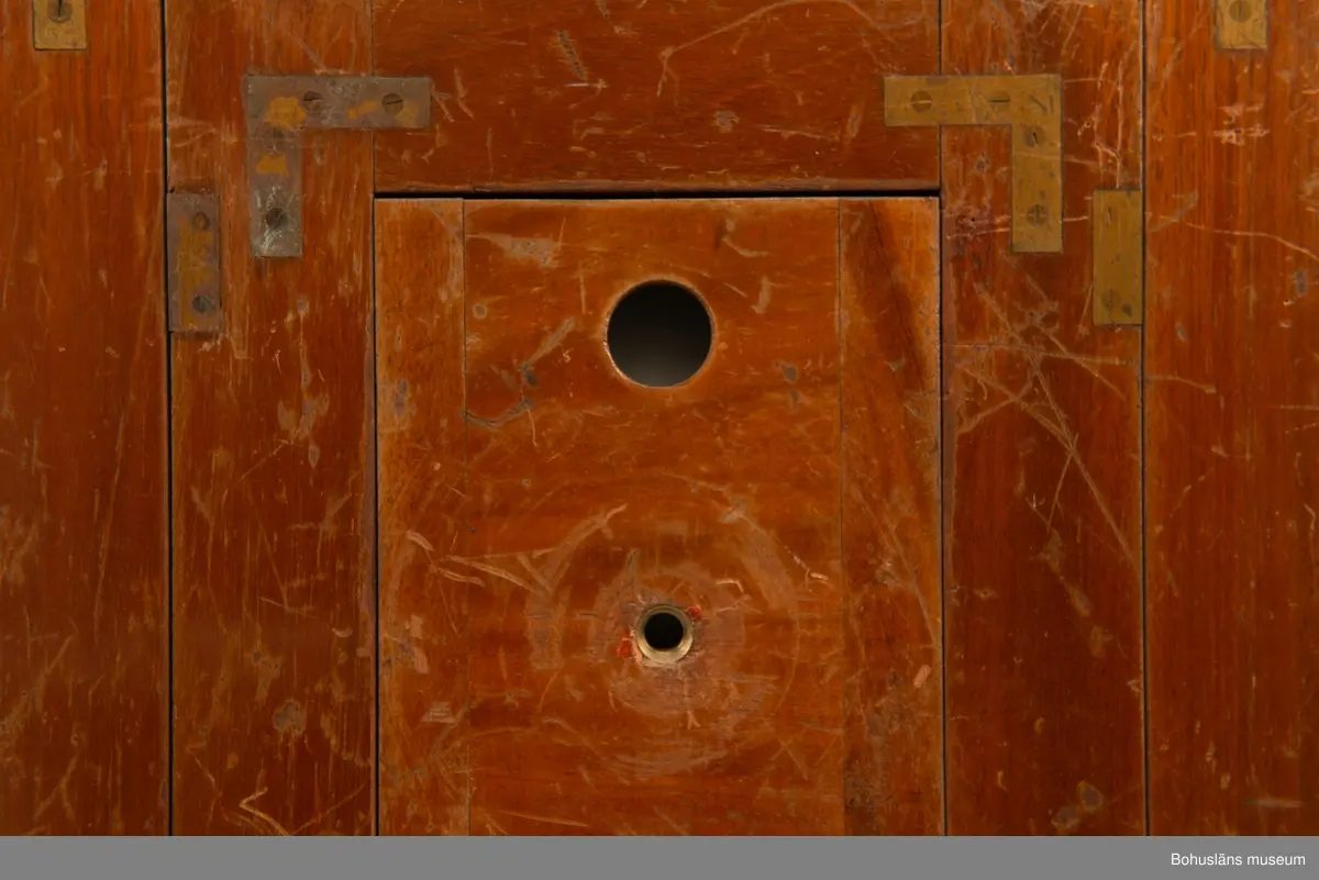 Kamerahuset tillverkat i mahogny med bälg i svart textil och läderhandtag med företagets namn inpräglat.
Kameran har ett dubelanastigmatiskt objektiv monterat,  tillverkat av C. P Goerz i Berlin med en brännvidd på 240 mm och en bländare som kunde ställas in mellan 1:4,8 och 1:384. Slutaren som monterades på objektivet saknas idag. Objektivet märkt: P G GOERTZ BERLIN DOPFEL ANASTIGMATER. Ett sammetsklätt objektivskydd i papp.
Till kameran hör UM034203 Stativ i fodral, UM034204 Objektiv och UM034205-UM034206 Ram.