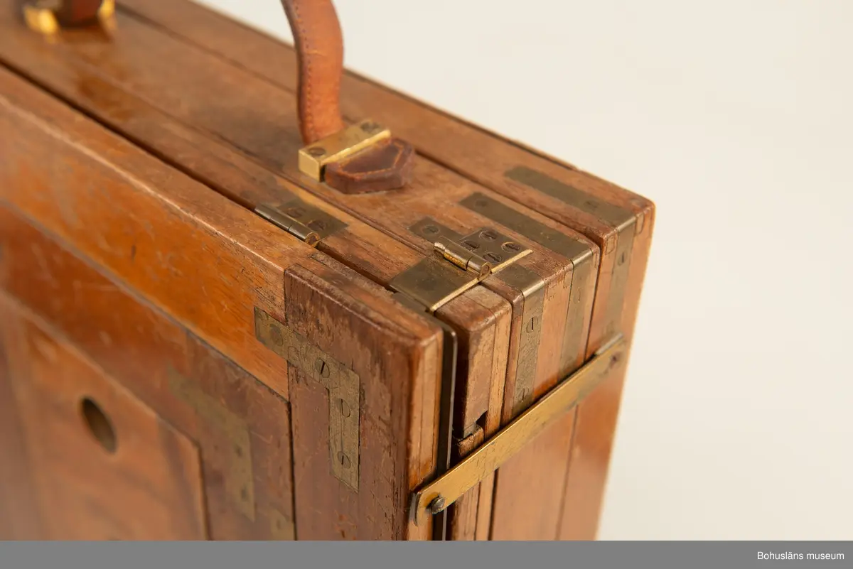 Kamerahuset tillverkat i mahogny med bälg i svart textil och läderhandtag med företagets namn inpräglat.
Kameran har ett dubelanastigmatiskt objektiv monterat,  tillverkat av C. P Goerz i Berlin med en brännvidd på 240 mm och en bländare som kunde ställas in mellan 1:4,8 och 1:384. Slutaren som monterades på objektivet saknas idag. Objektivet märkt: P G GOERTZ BERLIN DOPFEL ANASTIGMATER. Ett sammetsklätt objektivskydd i papp.
Till kameran hör UM034203 Stativ i fodral, UM034204 Objektiv och UM034205-UM034206 Ram.