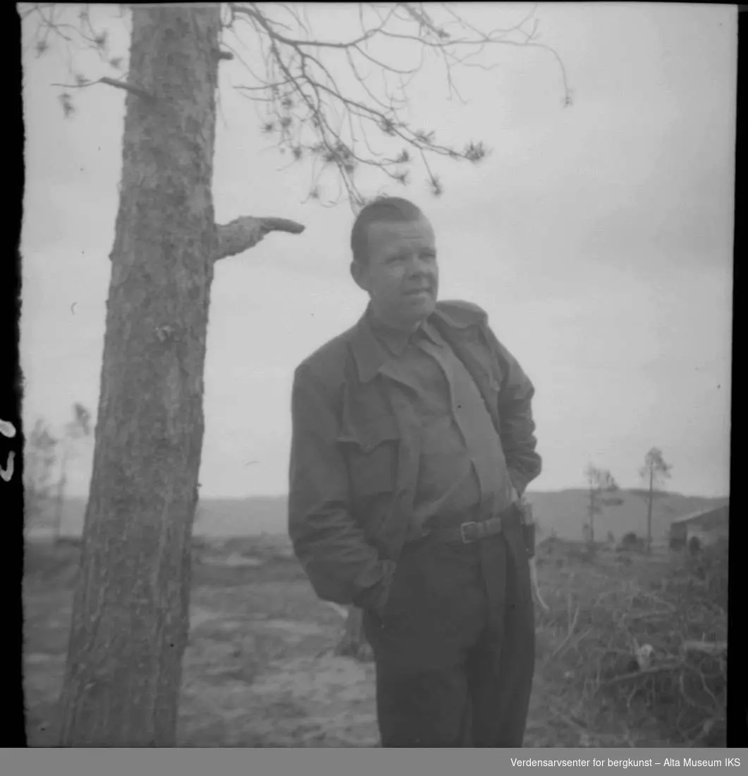 Otto Nielsen med et tre, nedhogd skog i bagrunn.