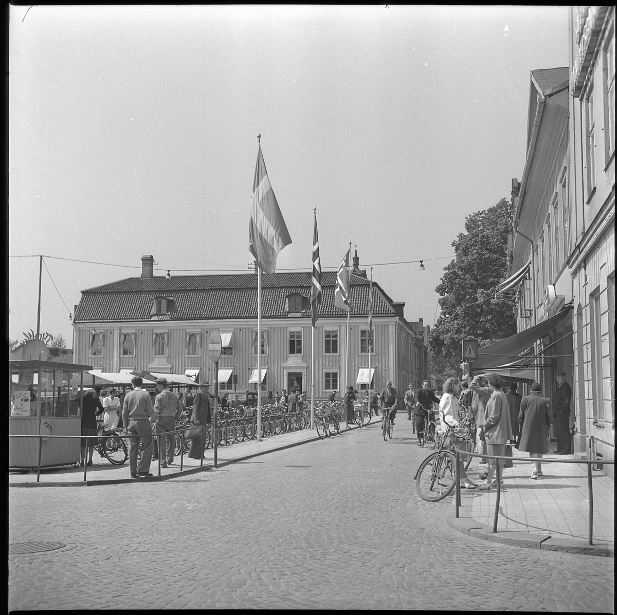 Svenska och norska flaggor på Stora torget. Tyrolens kiosk i förgrunden och Rådhuset i bakgrunden. 4 juni 1950
