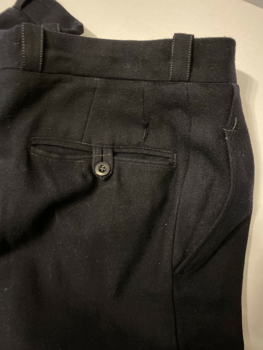 Uniformsbukse, del av NSB-uniform. Knappegylf, klokkelomme, sidelommer og baklommer med knapp.