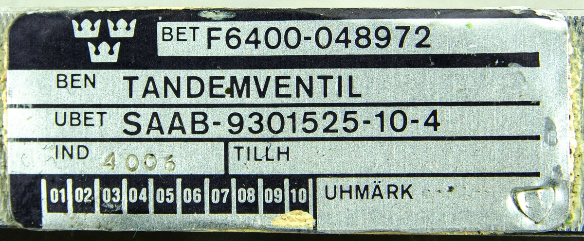 Tandemventil för  flygplan 37, Viggen. Ventilen ingår i höjd- och skevstyrsystem. Förvaras i grå plastlåda. I kortändarna finns ett gult tyghandtag som är fastnitat. Till föremålet hör ett Kontroll- och följekort.