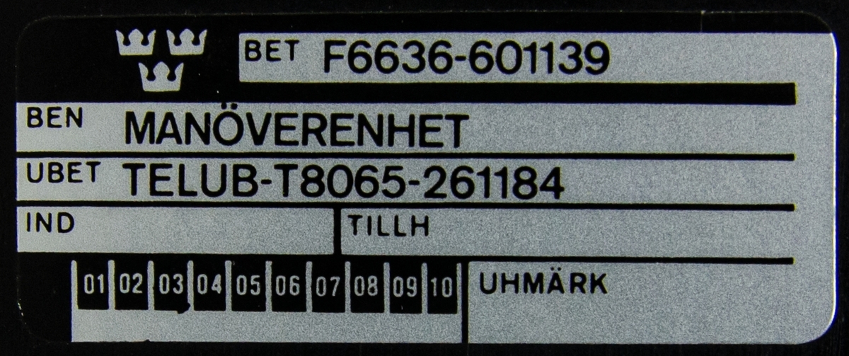 Manöverenhet, monterad i en svart rektangulär plåtlåda. Plexiglasskärm med karta och lampor, vita knappar nedanför.