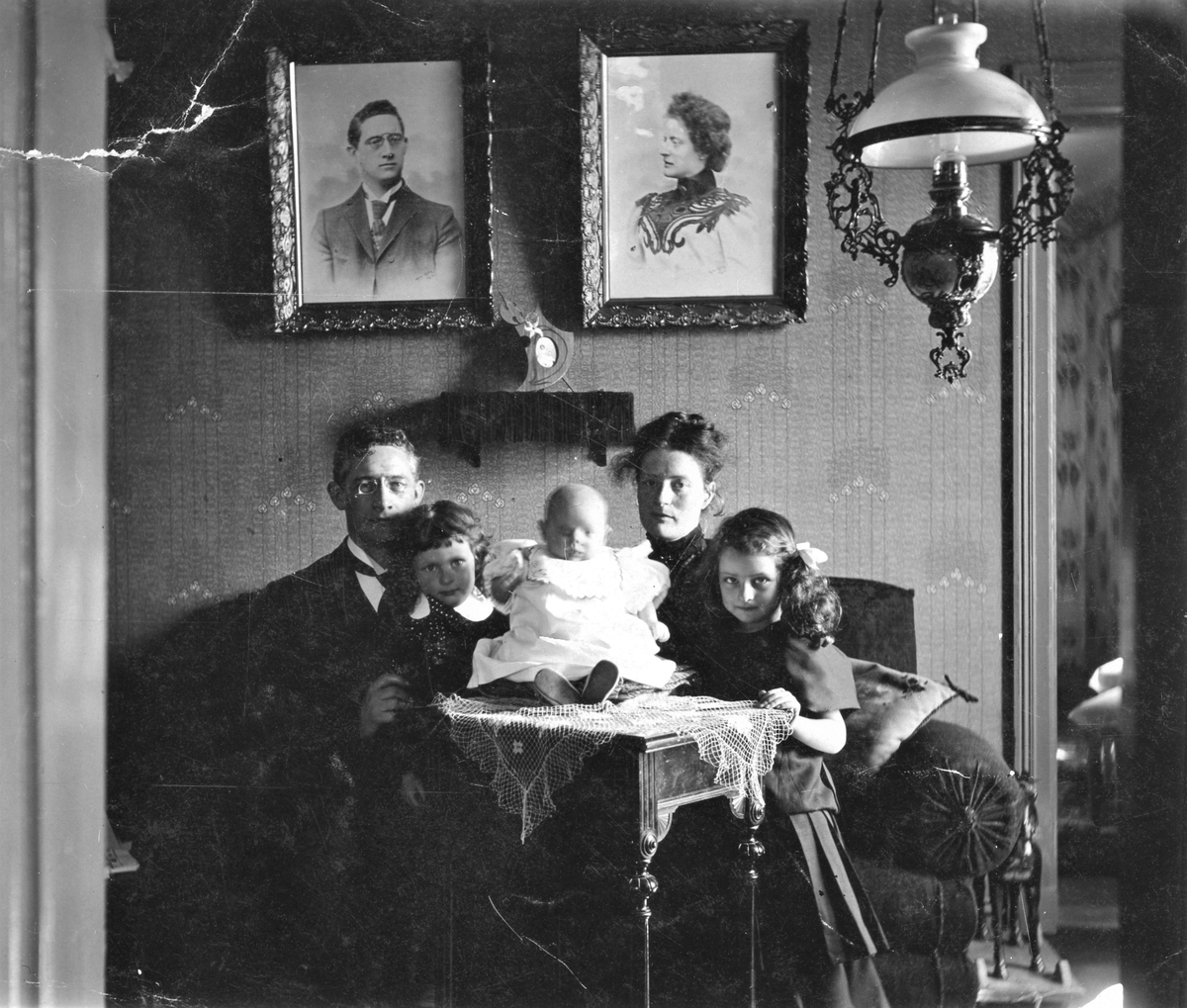 Curt och Anna Geier hemma i soffan med sina tre barn: lilla Jeanette ("Tullan") på bordet, Otto i Kurts knä och Ebba i Annas. Anna var dotter till Varbergs skräddarmästare Jean Svensson. Curt var en tysk ingenjör och chef över stora textilfabriker både i Norge och Sverige.