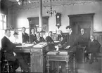 Tjänstemännen vid riksbankskontoret i Härnösand hösten 1910. 1.Josef Stenius, bokhållare. 2.Hilding Sundelin,e.o. tjänsteman. 3.Fabian Wållgren, kassör. 4.Magnus Nordström, registrator. 5.Josef Pettersson, bokhållare. 6.Reinhold Bruten, kamrer. 7.Einar Törnsten,e.o. tjänsteman. 8.Alrik Drakenberg, direktör. 9.Oskar Johnsson, e.o. tjänsteman.